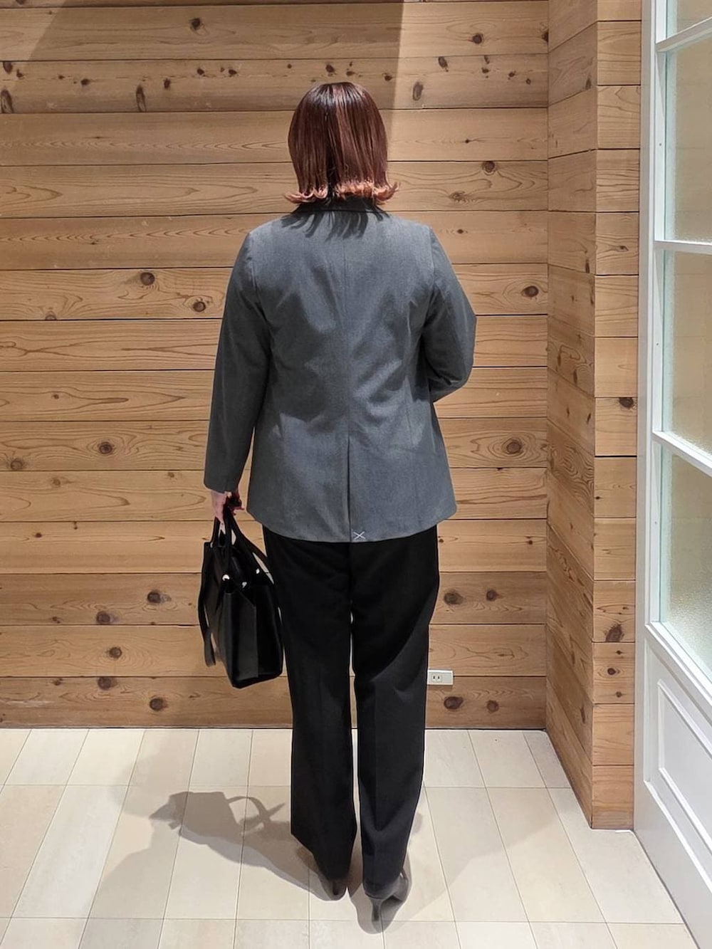 ブラック系のパンプス、ブラック系のスラックス、ホワイト系のシャツ/ブラウスを着用したレディースの冬コーディネートの3枚目の写真