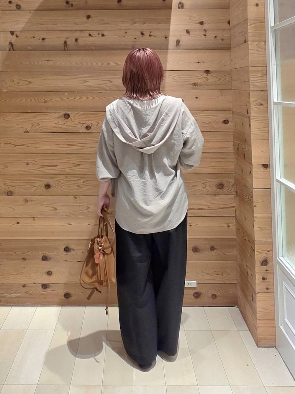 ベージュ系のハンドバッグ、ブラック系のローファー、ホワイト系のTシャツ/カットソーを着用したレディースの夏コーディネートの3枚目の写真