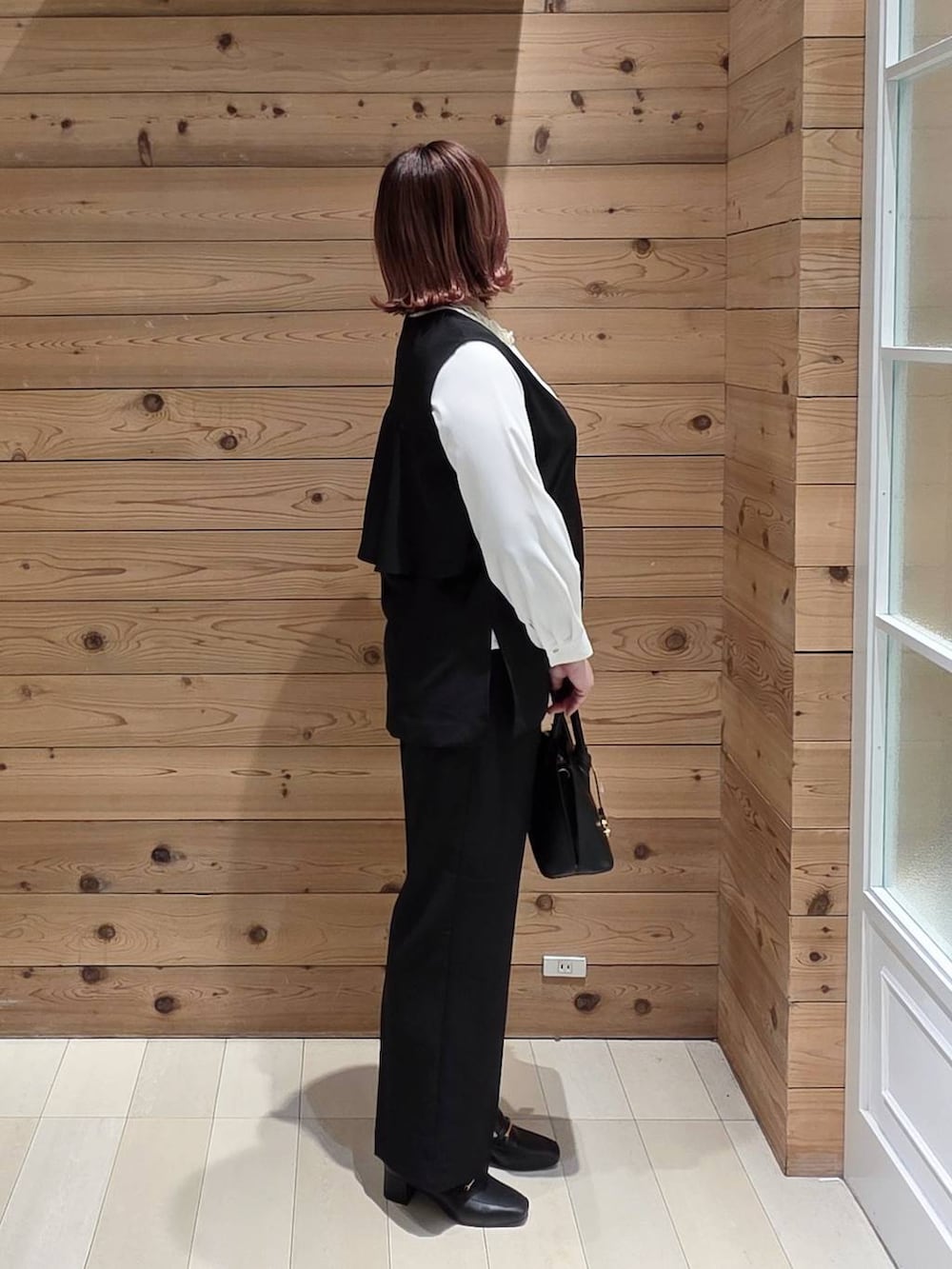 ブラック系のローファー、ブラック系のショルダーバッグ、ホワイト系のシャツ/ブラウスを着用したレディースの冬コーディネートの2枚目の写真