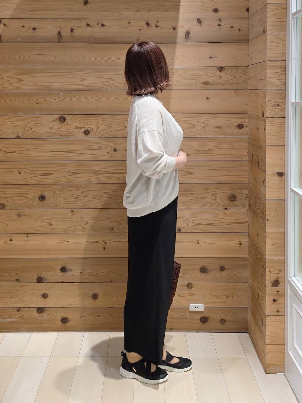 ブラック系のスニーカー、ホワイト系のTシャツ/カットソー、ブラック系のスカートを着用したレディースの春コーディネートの2枚目の写真