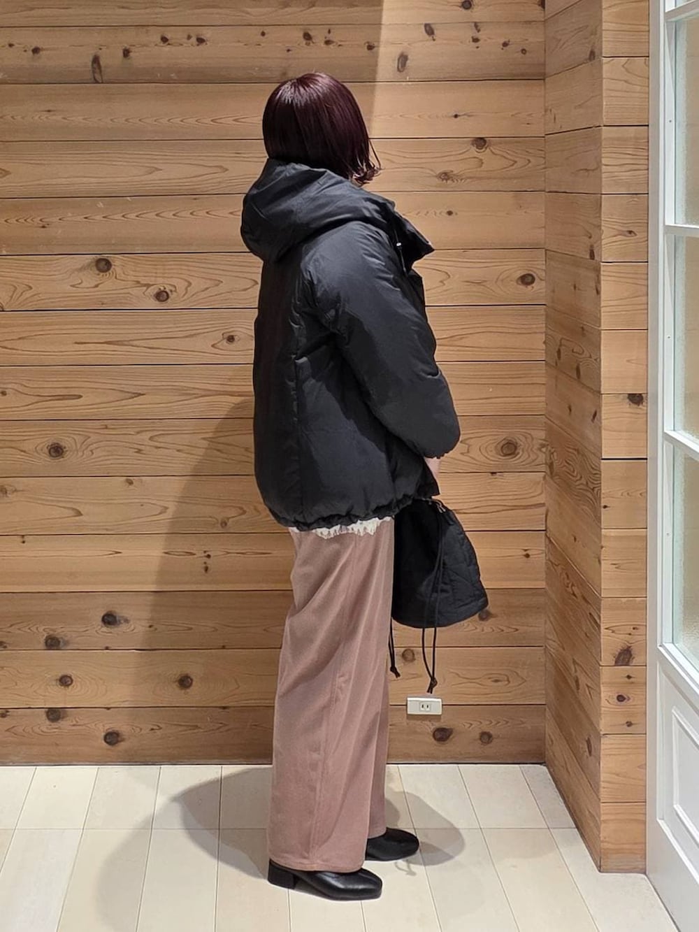 ブラック系のダウンジャケット/コート、ピンク系のその他パンツ、ブラック系のハンドバッグを着用したレディースの冬コーディネートの2枚目の写真