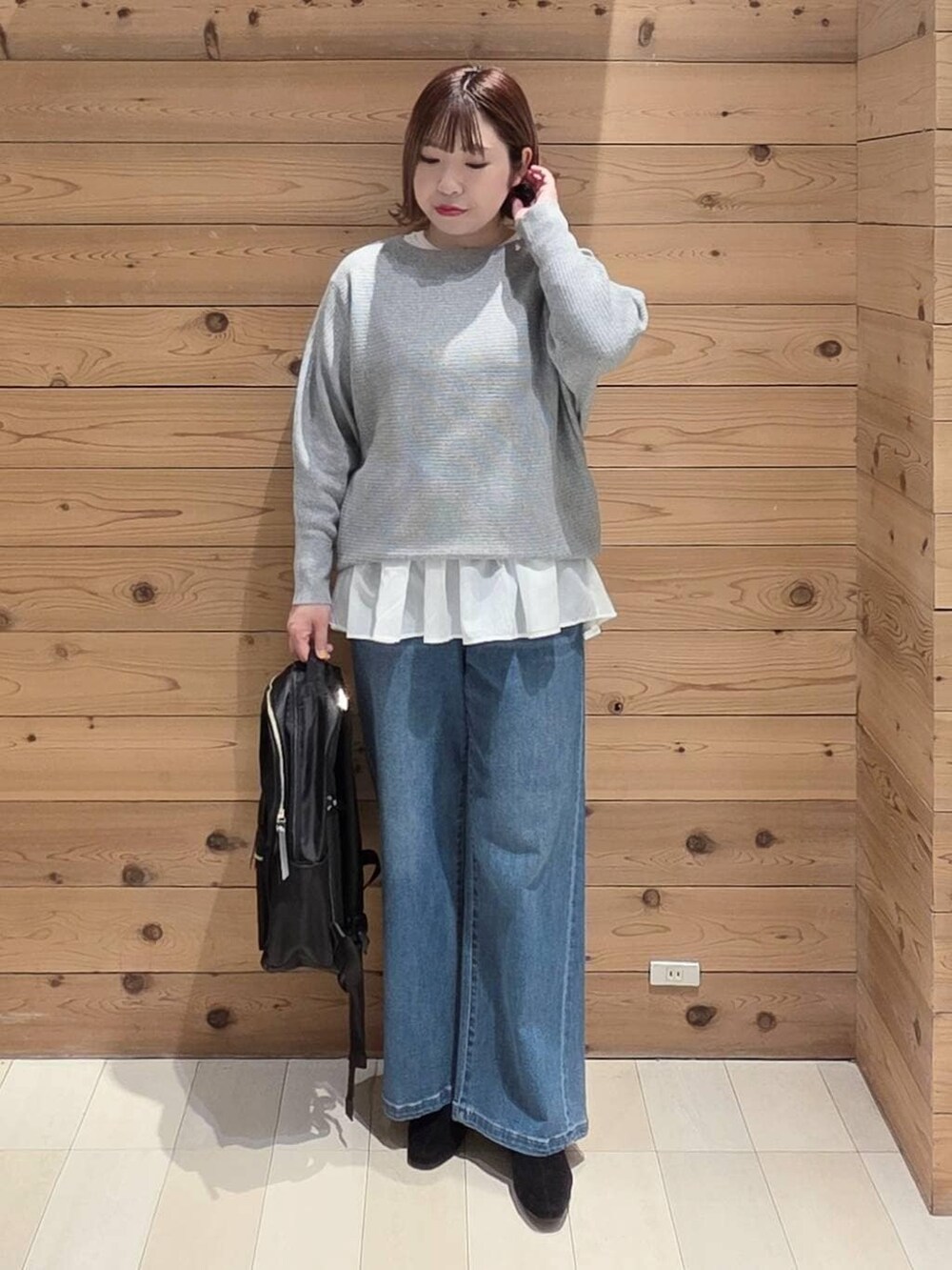 ブラウン系のブルゾン、ブラック系のバックパック/リュック、ホワイト系のTシャツ/カットソーを着用したレディースの冬コーディネートの4枚目の写真