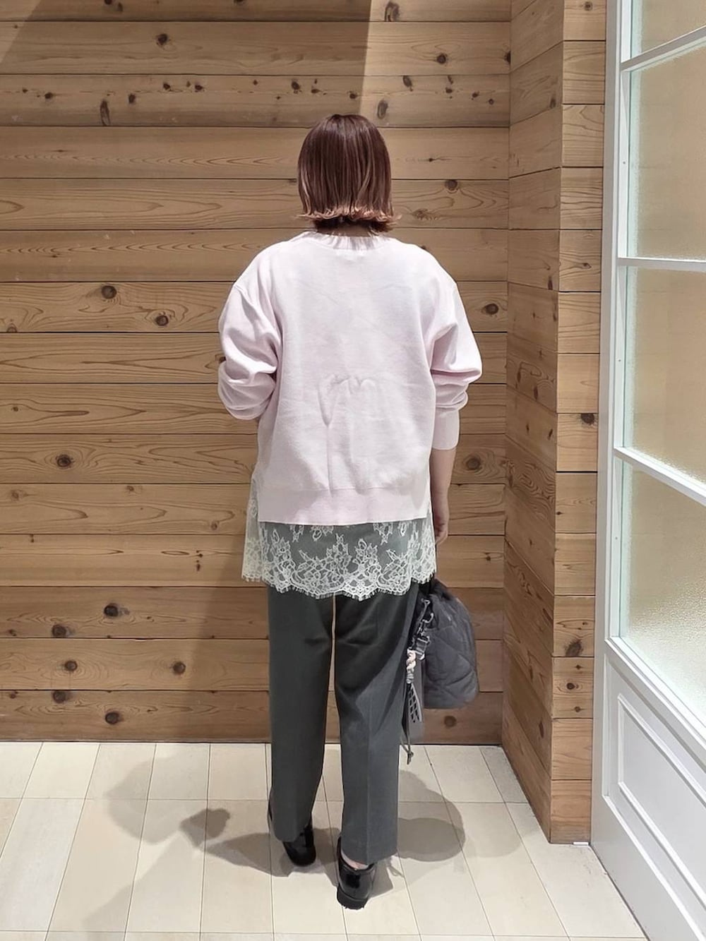 ブラック系のローファー、グレー系のハンドバッグ、グレー系のスラックスを着用したレディースの春コーディネートの3枚目の写真