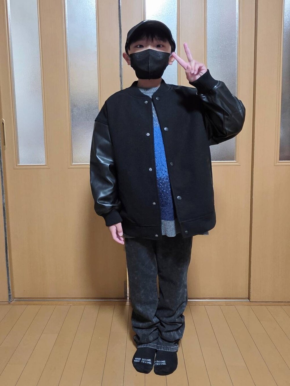 ブラック系のブルゾン、ブラック系のデニムパンツ、グレー系のニット/セーターを着用したキッズの冬コーディネートの4枚目の写真