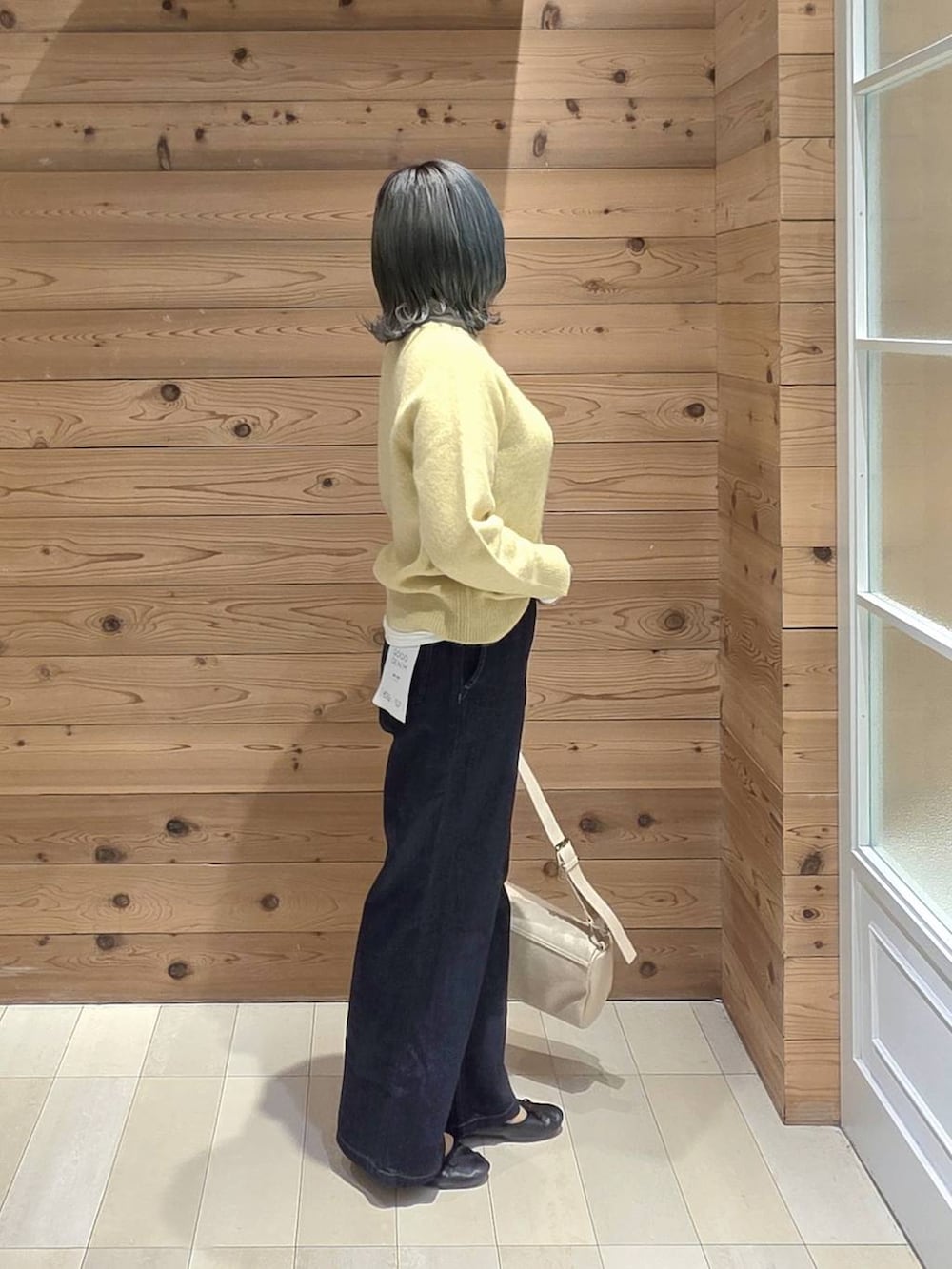 ブラック系のバレエシューズ、ブルー系のデニムパンツ、イエロー系のニット/セーターを着用したレディースの秋コーディネートの2枚目の写真