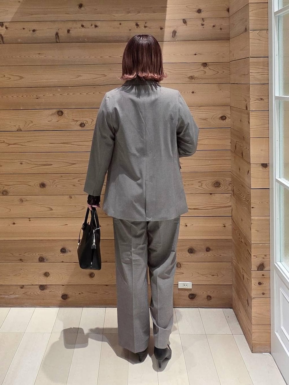 ブラック系のショルダーバッグ、ブラック系のパンプス、ブラック系のTシャツ/カットソーを着用したレディースの冬コーディネートの3枚目の写真