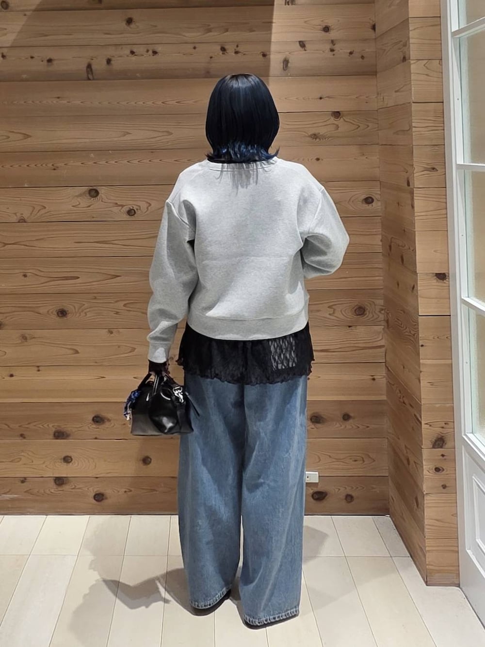 ブルー系のデニムパンツ、グレー系のカーディガン/ボレロ、ブラック系のバレエシューズを着用したレディースの秋コーディネートの3枚目の写真