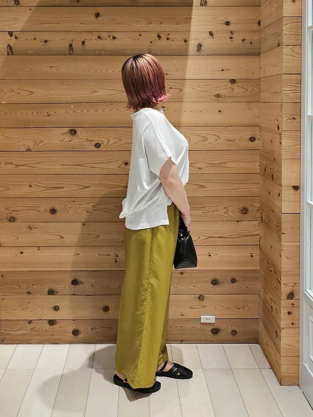 ブラック系のショルダーバッグ、ホワイト系のTシャツ/カットソー、イエロー系のその他パンツを着用したレディースの夏コーディネートの2枚目の写真
