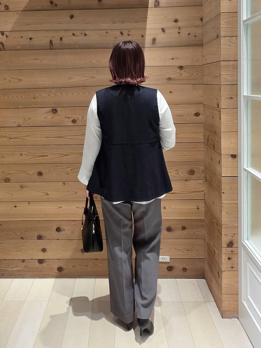 ブラック系のショルダーバッグ、ブラック系のパンプス、ブルー系のセットアップを着用したレディースの冬コーディネートの3枚目の写真