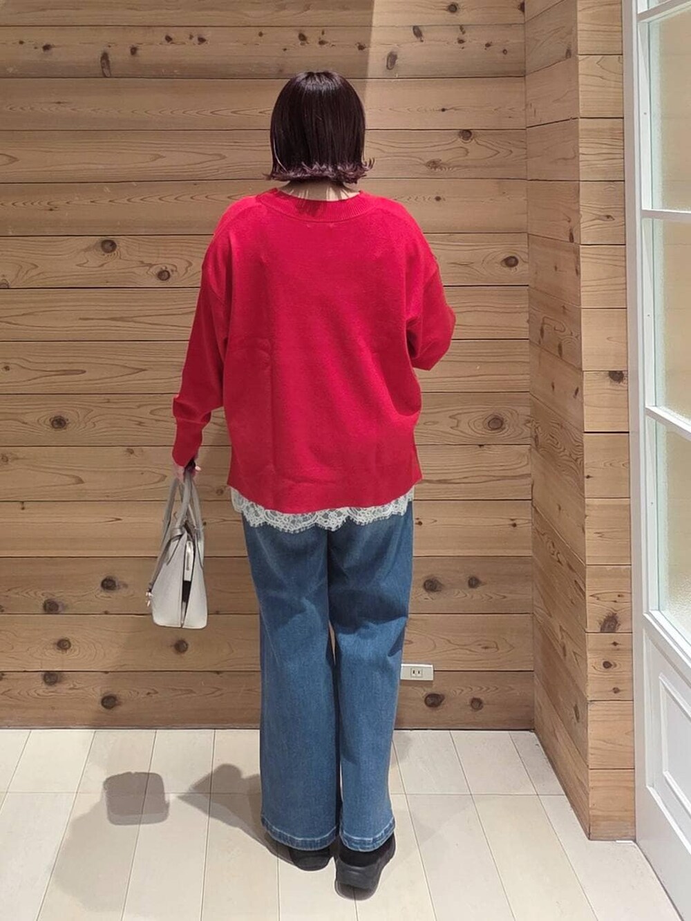 ホワイト系のショルダーバッグ、ブラック系のダウンジャケット/コート、ブラック系のブーツを着用したレディースの冬コーディネートの3枚目の写真