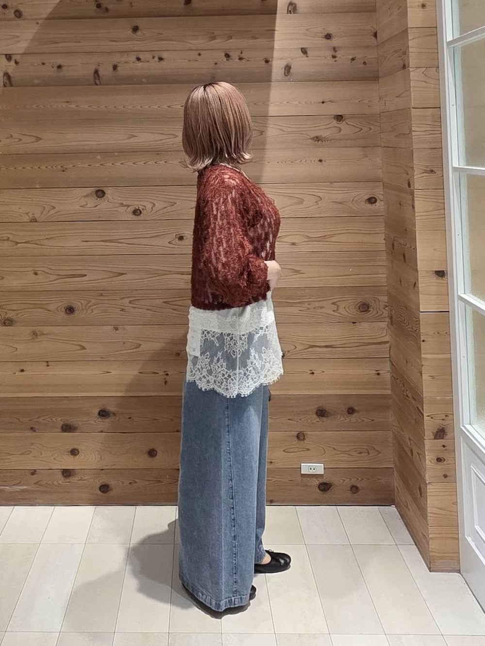 レッド系のカーディガン/ボレロ、ブラック系のバレエシューズ、グレー系のトートバッグを着用したレディースの秋コーディネートの2枚目の写真