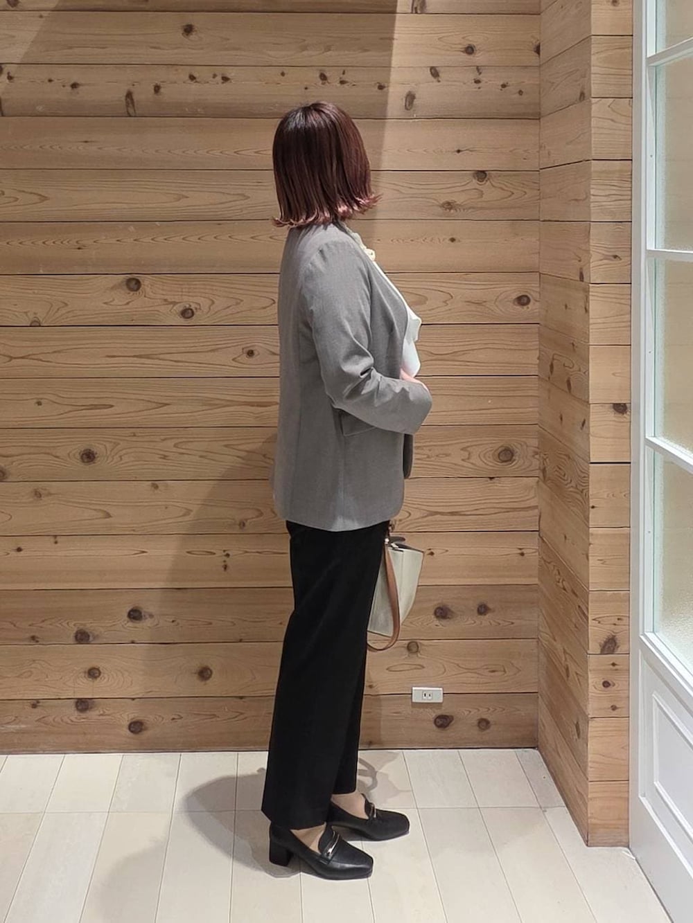 ブラック系のローファー、ブラック系のスラックス、ホワイト系のシャツ/ブラウスを着用したレディースの冬コーディネートの2枚目の写真