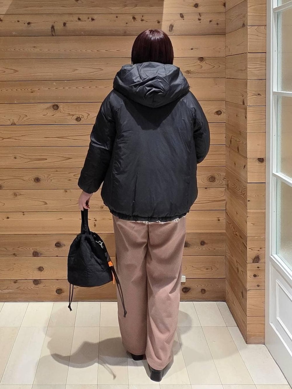 ブラック系のダウンジャケット/コート、ピンク系のその他パンツ、ブラック系のハンドバッグを着用したレディースの冬コーディネートの3枚目の写真