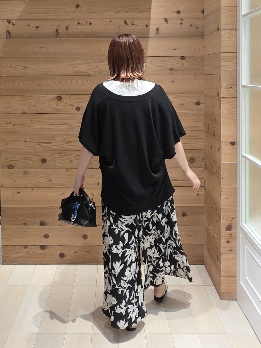 ブラック系のカーディガン/ボレロ、ホワイト系のタンクトップ、ブラック系のボストンバッグを着用したレディースの夏コーディネートの3枚目の写真