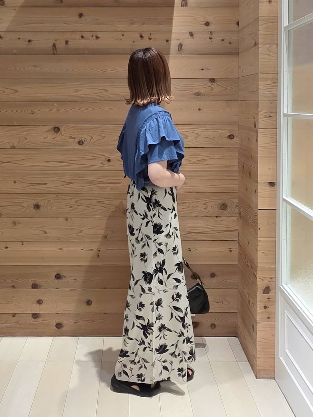 ホワイト系のその他パンツ、ブラック系のサンダル、ブルー系のTシャツ/カットソーを着用したレディースの夏コーディネートの2枚目の写真