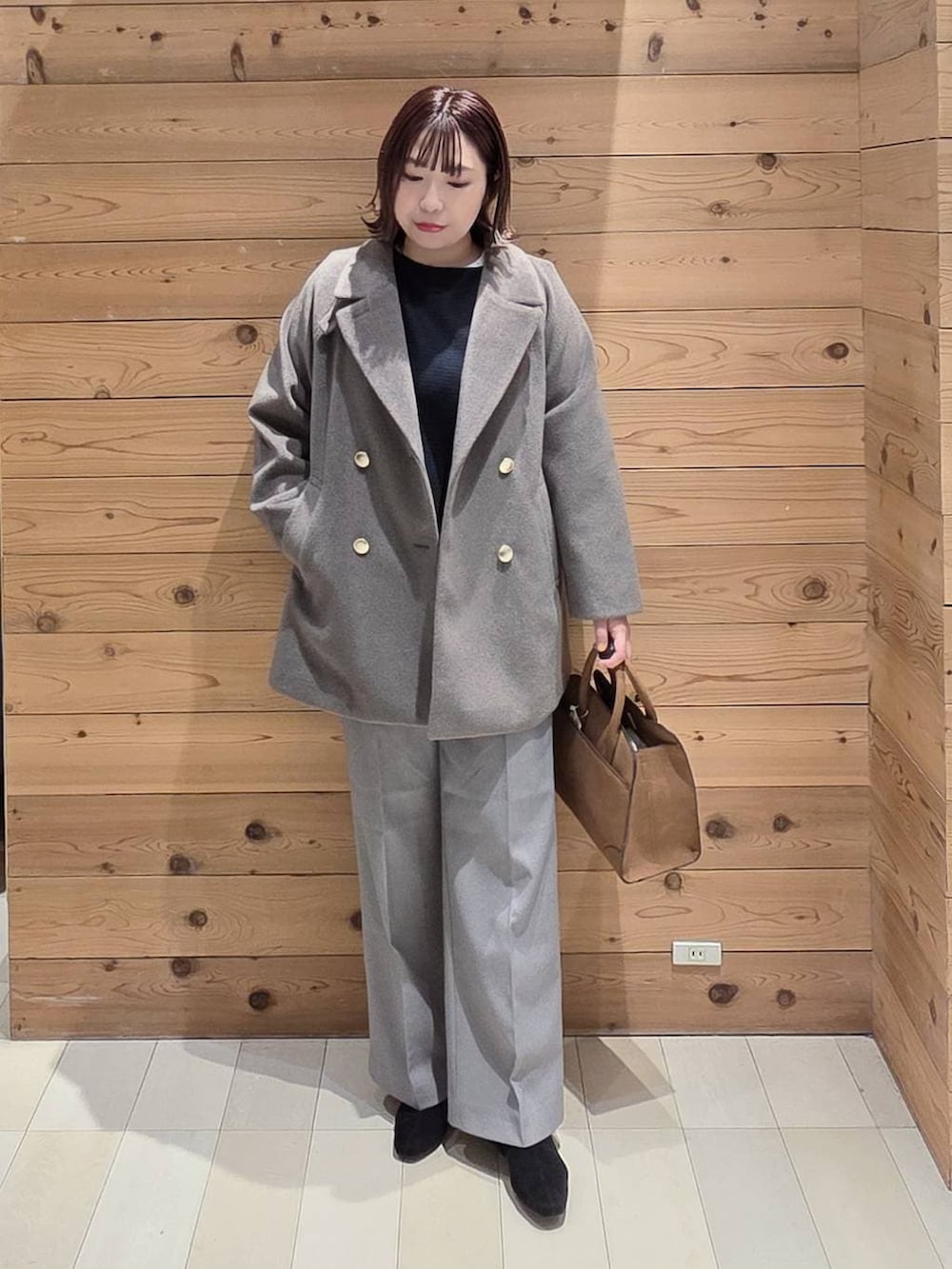 ブラウン系のチェスターコート、グレー系のその他パンツ、ベージュ系のショルダーバッグを着用したレディースの冬コーディネートの4枚目の写真