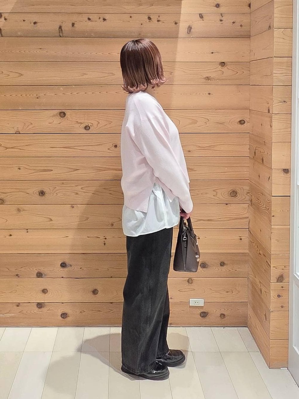 ブラック系のローファー、ブラウン系のショルダーバッグ、ベージュ系のマウンテンパーカーを着用したレディースの春コーディネートの2枚目の写真