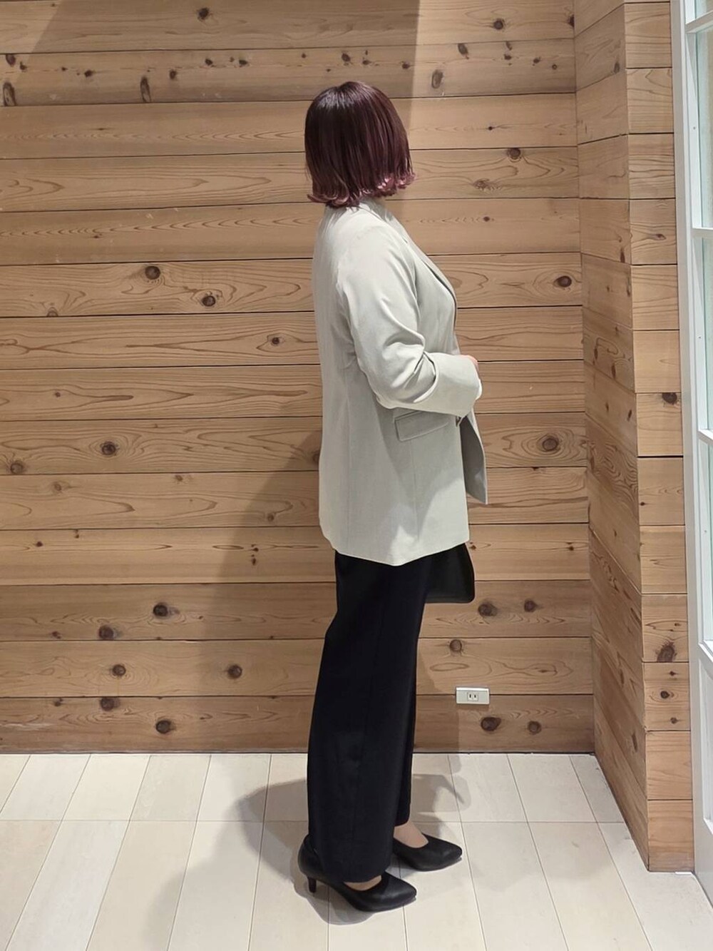 ブラック系のショルダーバッグ、ブラック系のパンプス、ベージュ系のテーラードジャケットを着用したレディースの冬コーディネートの2枚目の写真