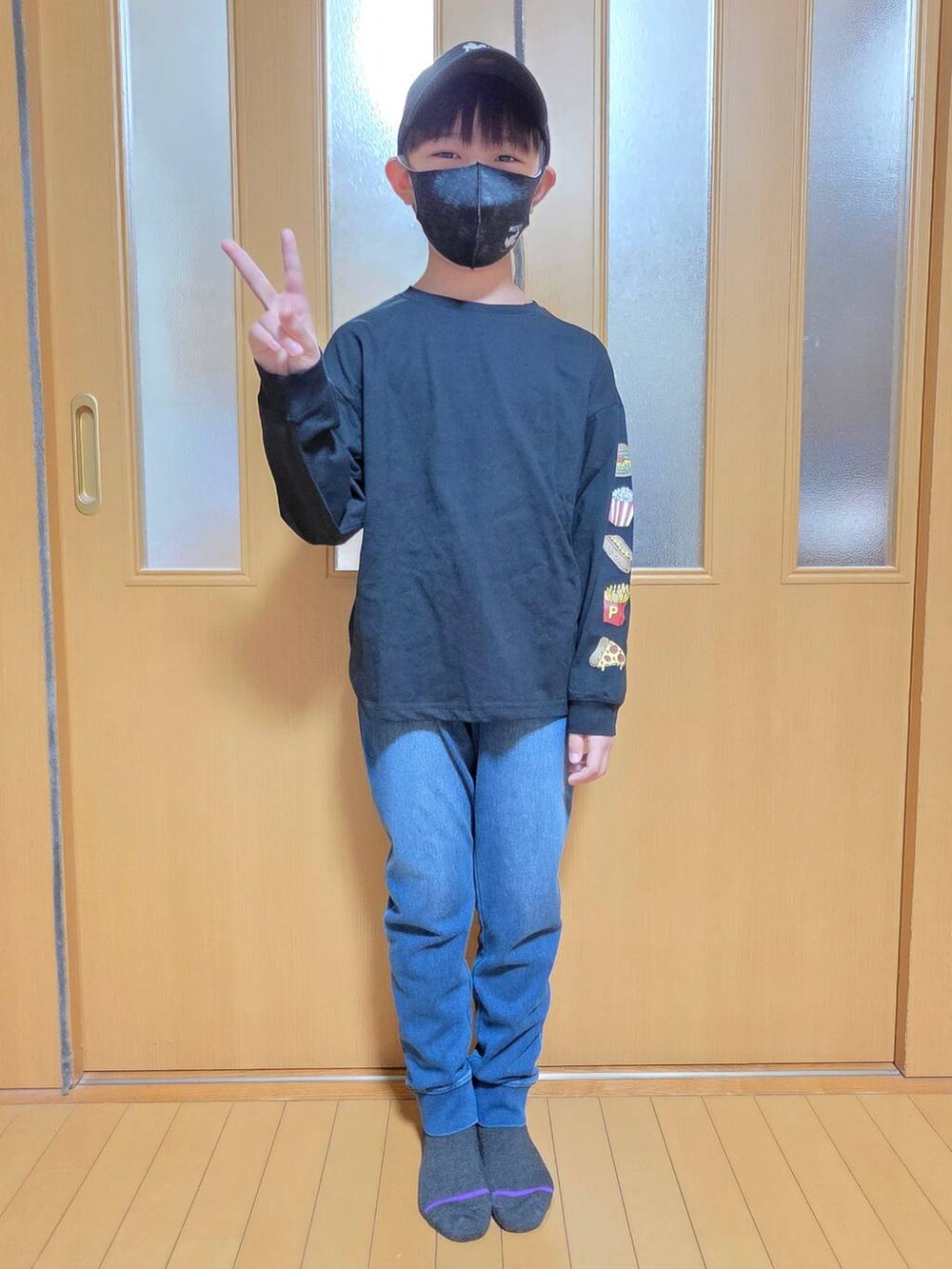 ブルー系のデニムパンツ、グリーン系のカーゴパンツ、ブラック系のキャップを着用したキッズの秋コーディネートの2枚目の写真