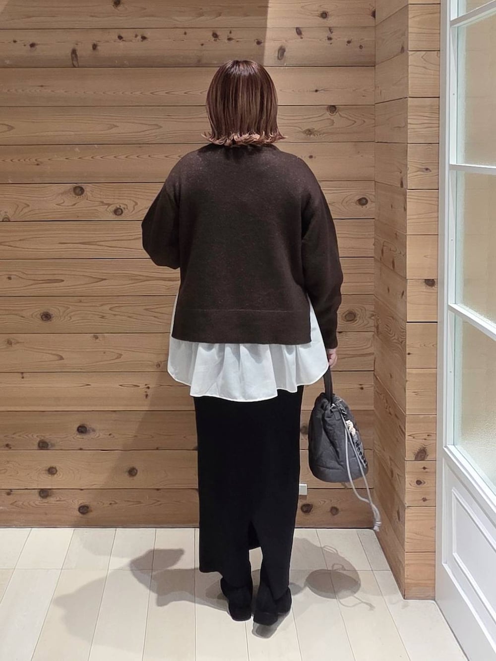 ベージュ系のブルゾン、グレー系のハンドバッグ、ブラウン系のニット/セーターを着用したレディースの冬コーディネートの3枚目の写真