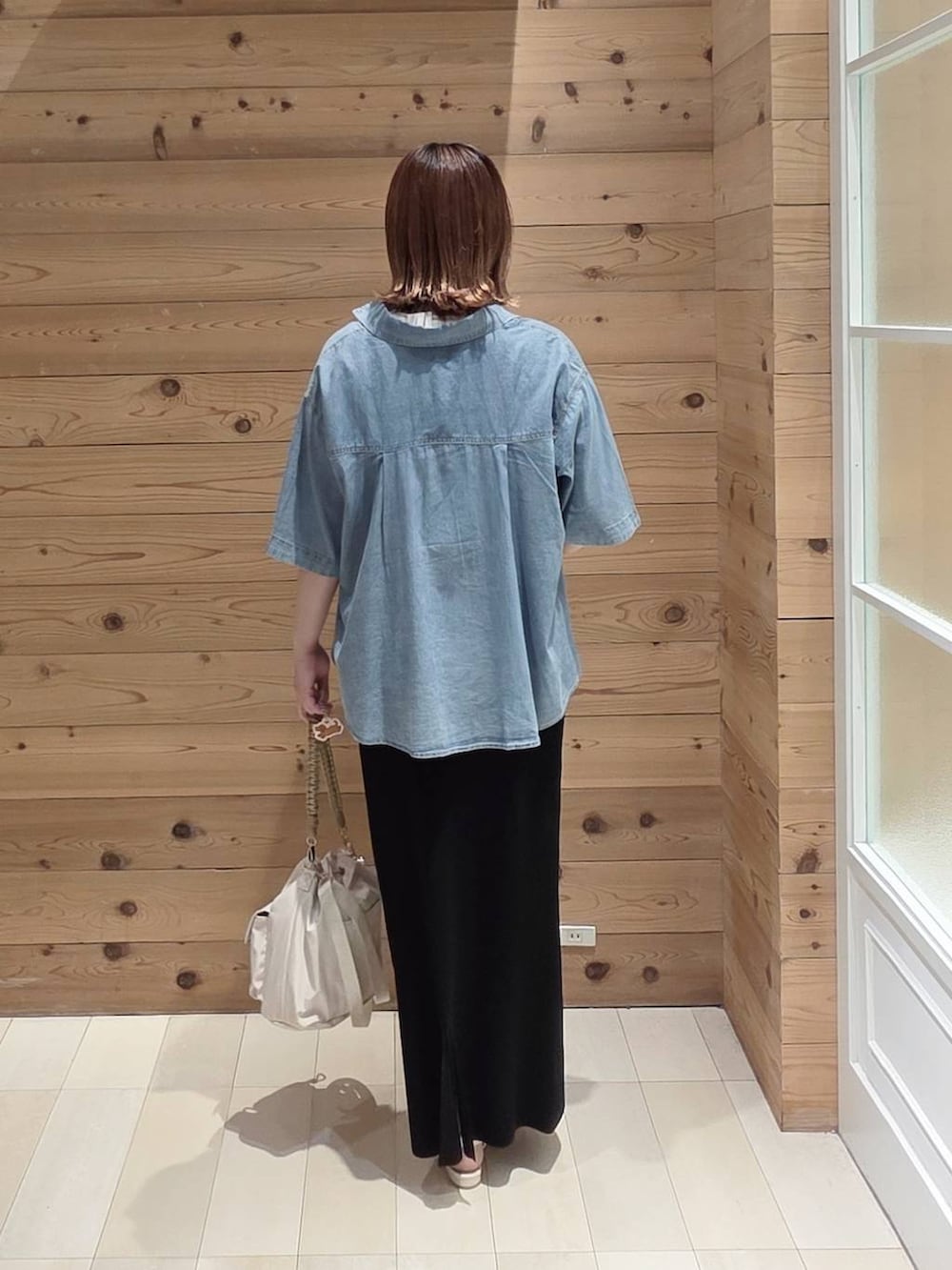 ブルー系のシャツ/ブラウス、ブラック系のスカート、ホワイト系のTシャツ/カットソーを着用したレディースの夏コーディネートの3枚目の写真