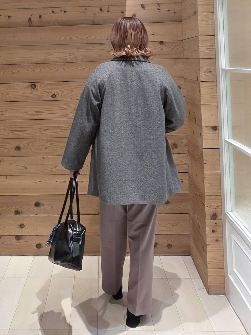 ブラック系のボストンバッグ、グレー系のチェスターコート、レッド系のニット/セーターを着用したレディースの冬コーディネートの3枚目の写真