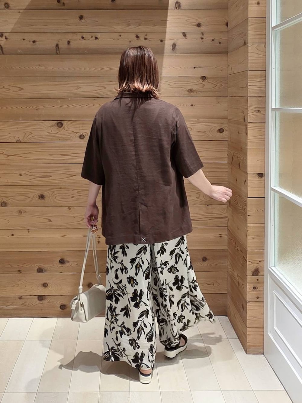 ブラウン系のテーラードジャケット、ホワイト系のその他パンツ、ブラック系のサンダルを着用したレディースの夏コーディネートの3枚目の写真