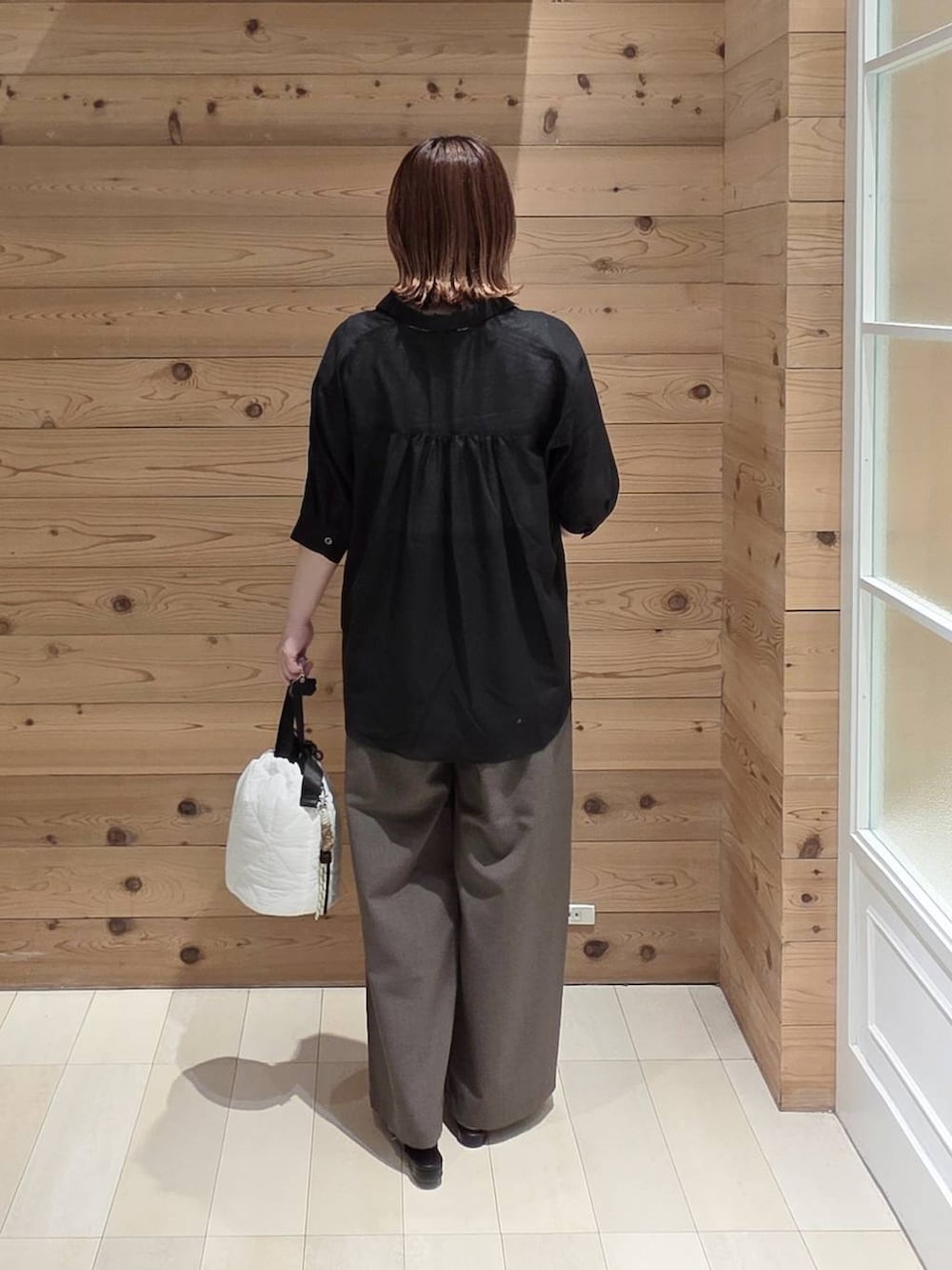 ホワイト系のハンドバッグ、ブラウン系のその他パンツ、ホワイト系のタンクトップを着用したレディースの夏コーディネートの3枚目の写真