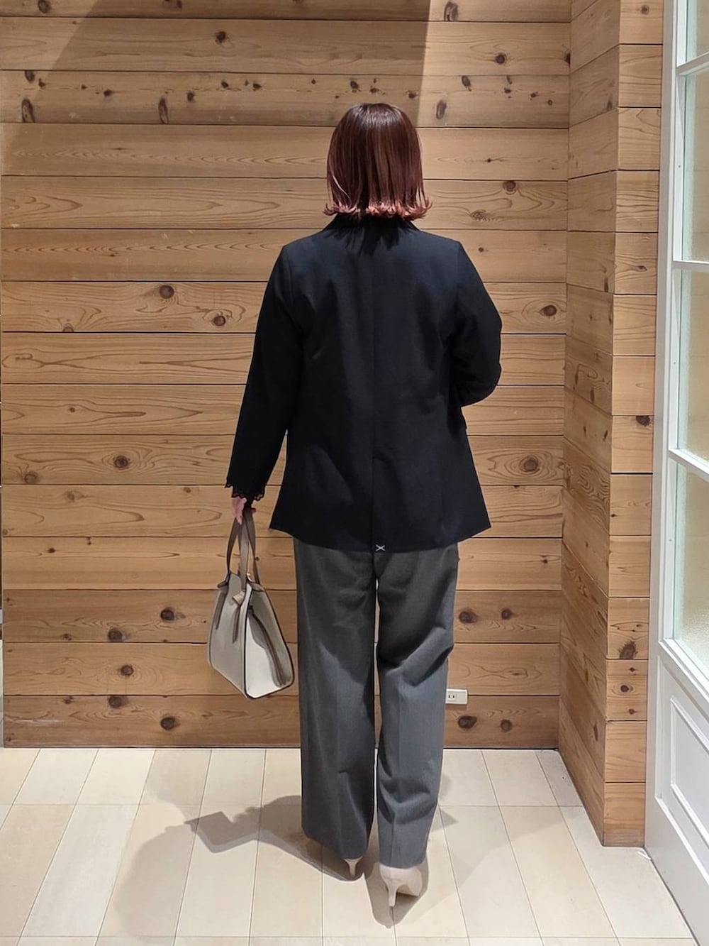 ホワイト系のショルダーバッグ、ホワイト系のパンプス、ブラック系のシャツ/ブラウスを着用したレディースの冬コーディネートの3枚目の写真