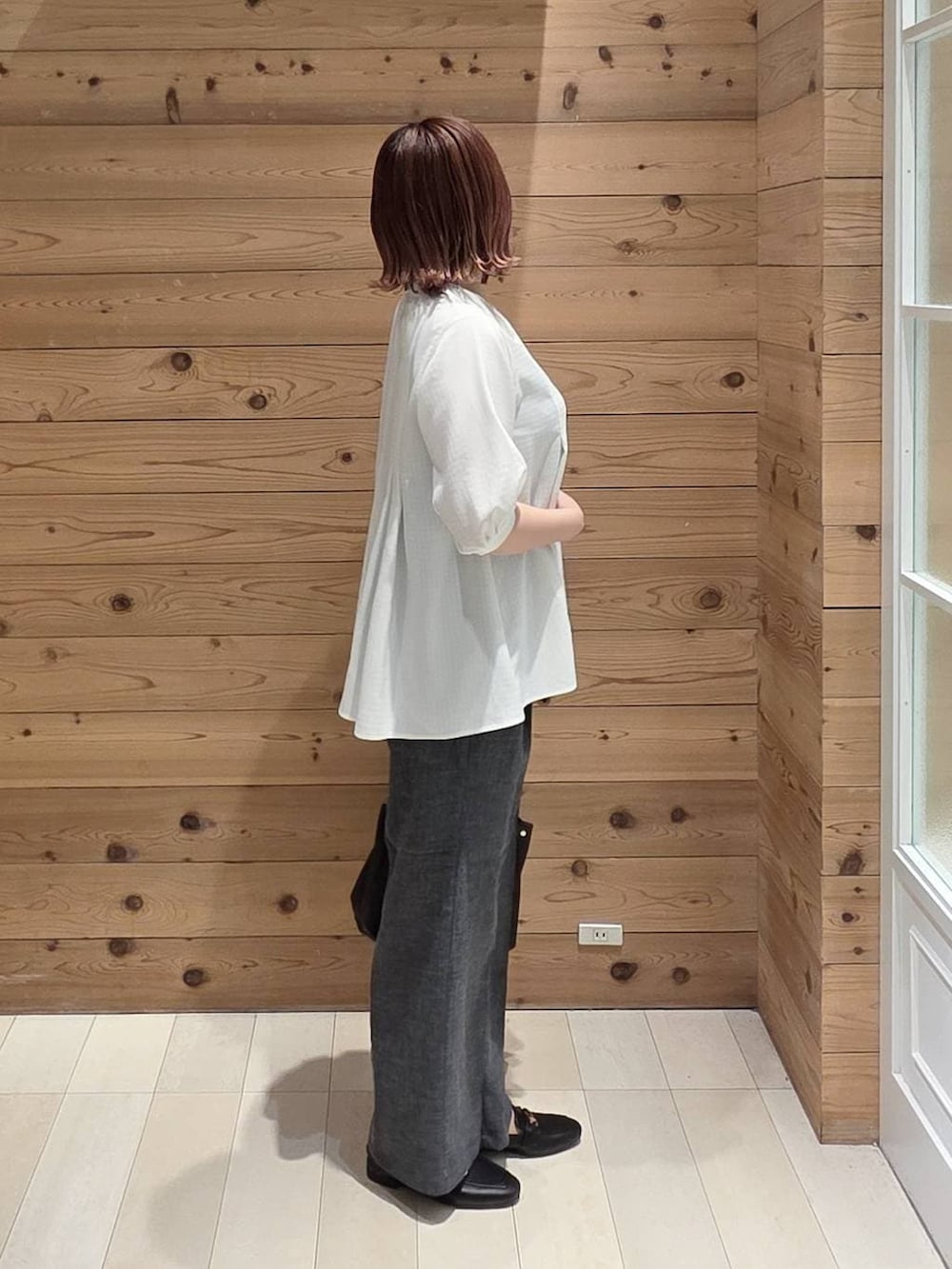 ブラック系のローファー、ブラック系のハンドバッグ、グレー系のその他パンツを着用したレディースの春コーディネートの2枚目の写真