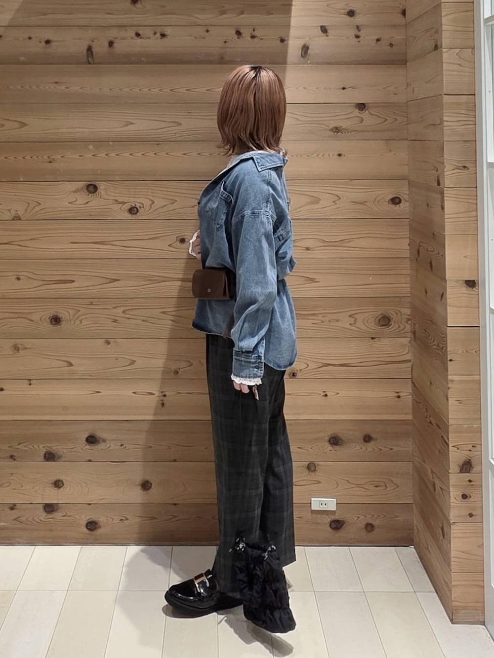 ブラウン系のボディバッグ/ウエストポーチ、ブラック系のローファー、ホワイト系のTシャツ/カットソーを着用したレディースの秋コーディネートの2枚目の写真