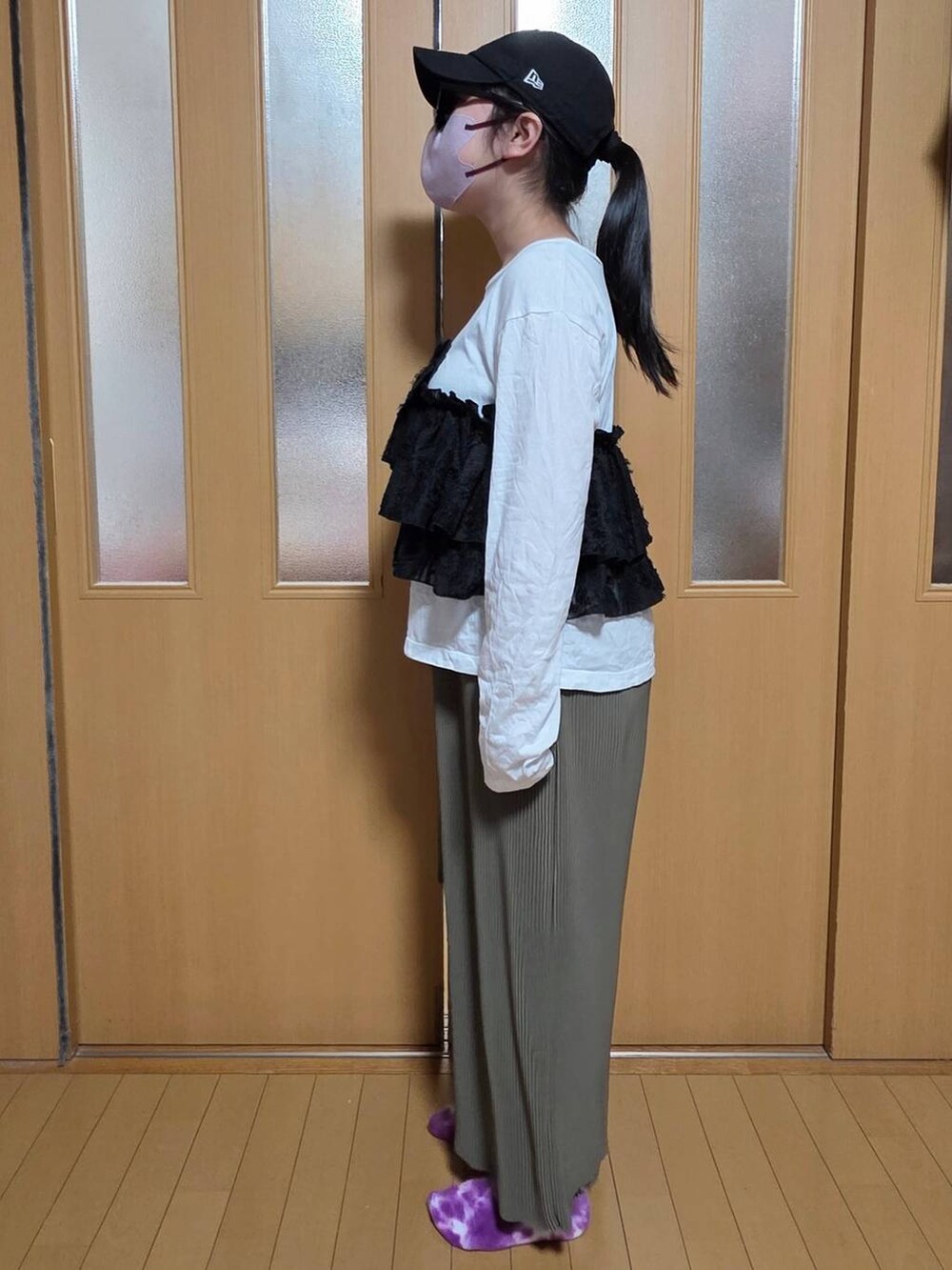 ホワイト系のTシャツ/カットソー、グリーン系のスカート、ブラック系のキャップを着用したキッズの秋コーディネートの2枚目の写真