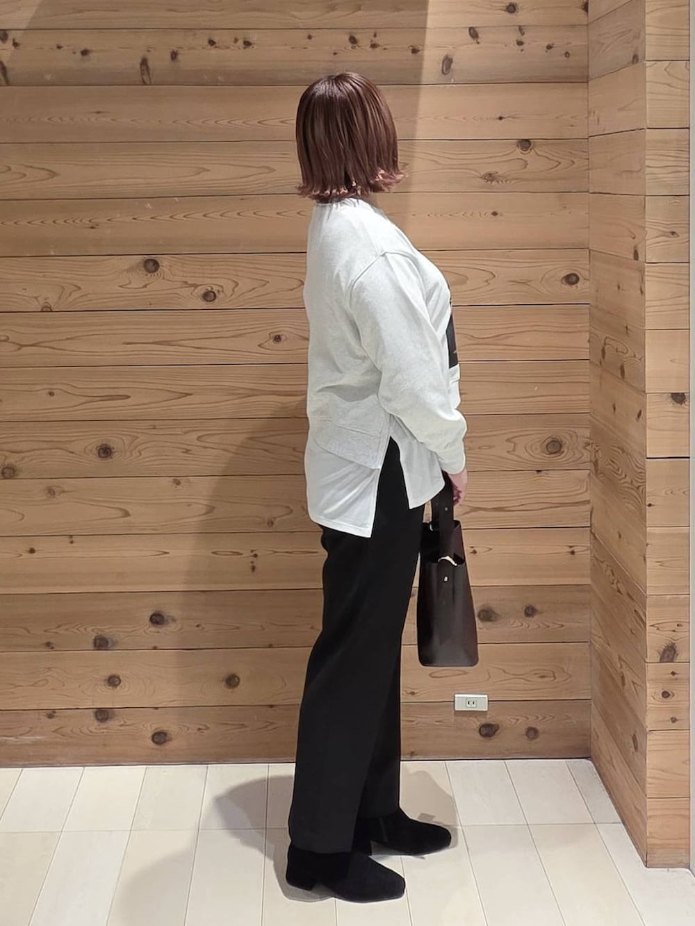 ブラウン系のショルダーバッグ、ベージュ系のチェスターコート、ブラック系のその他パンツを着用したレディースの秋コーディネートの2枚目の写真