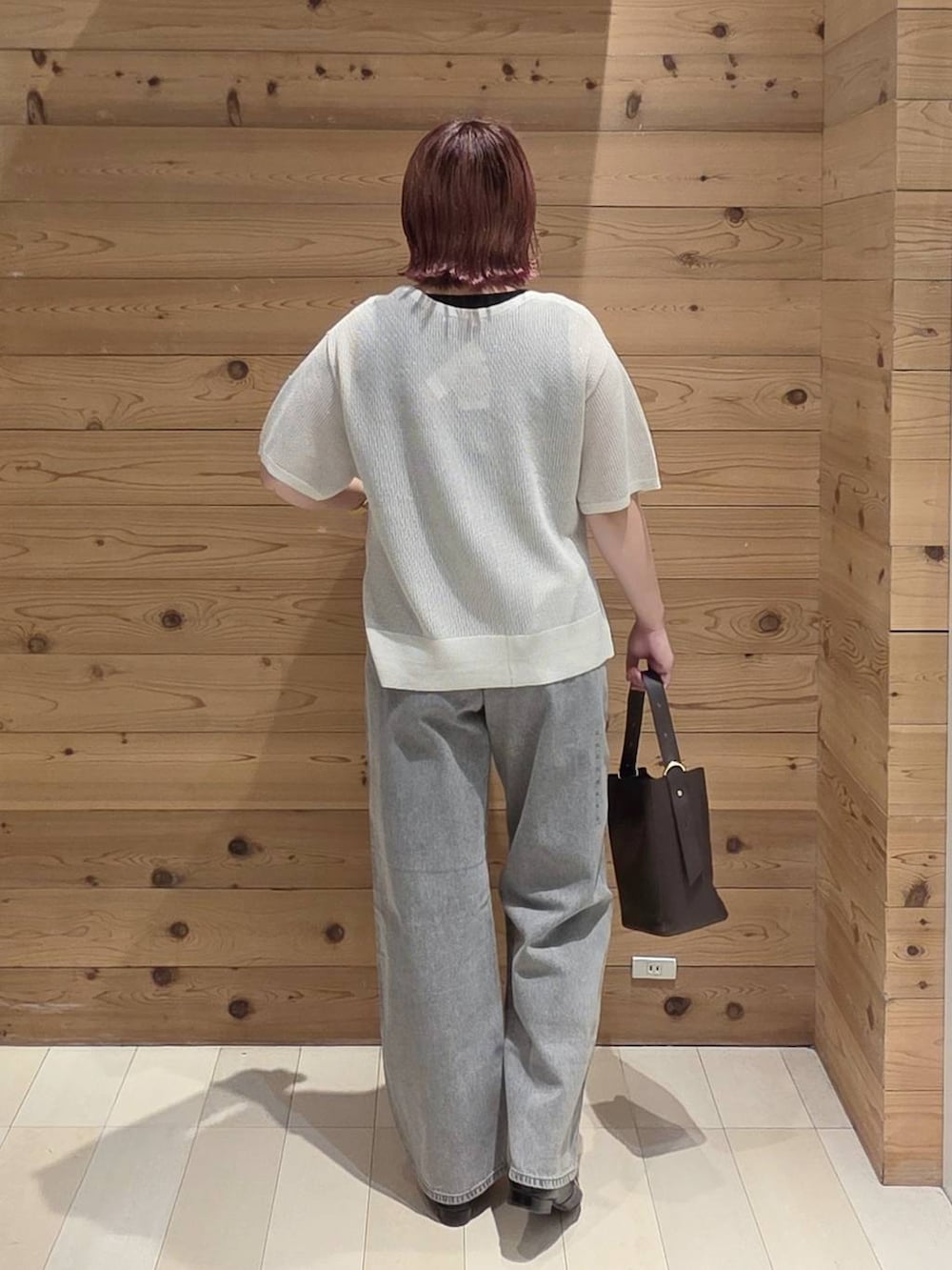 グレー系のデニムパンツ、ブラック系のショルダーバッグ、ブラック系のタンクトップを着用したレディースの夏コーディネートの3枚目の写真