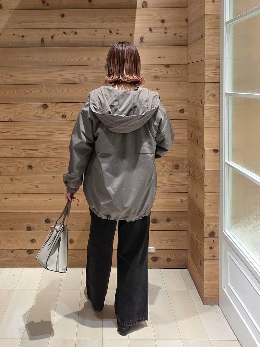 ブラック系のローファー、ホワイト系のショルダーバッグ、ブラック系のデニムパンツを着用したレディースの春コーディネートの3枚目の写真