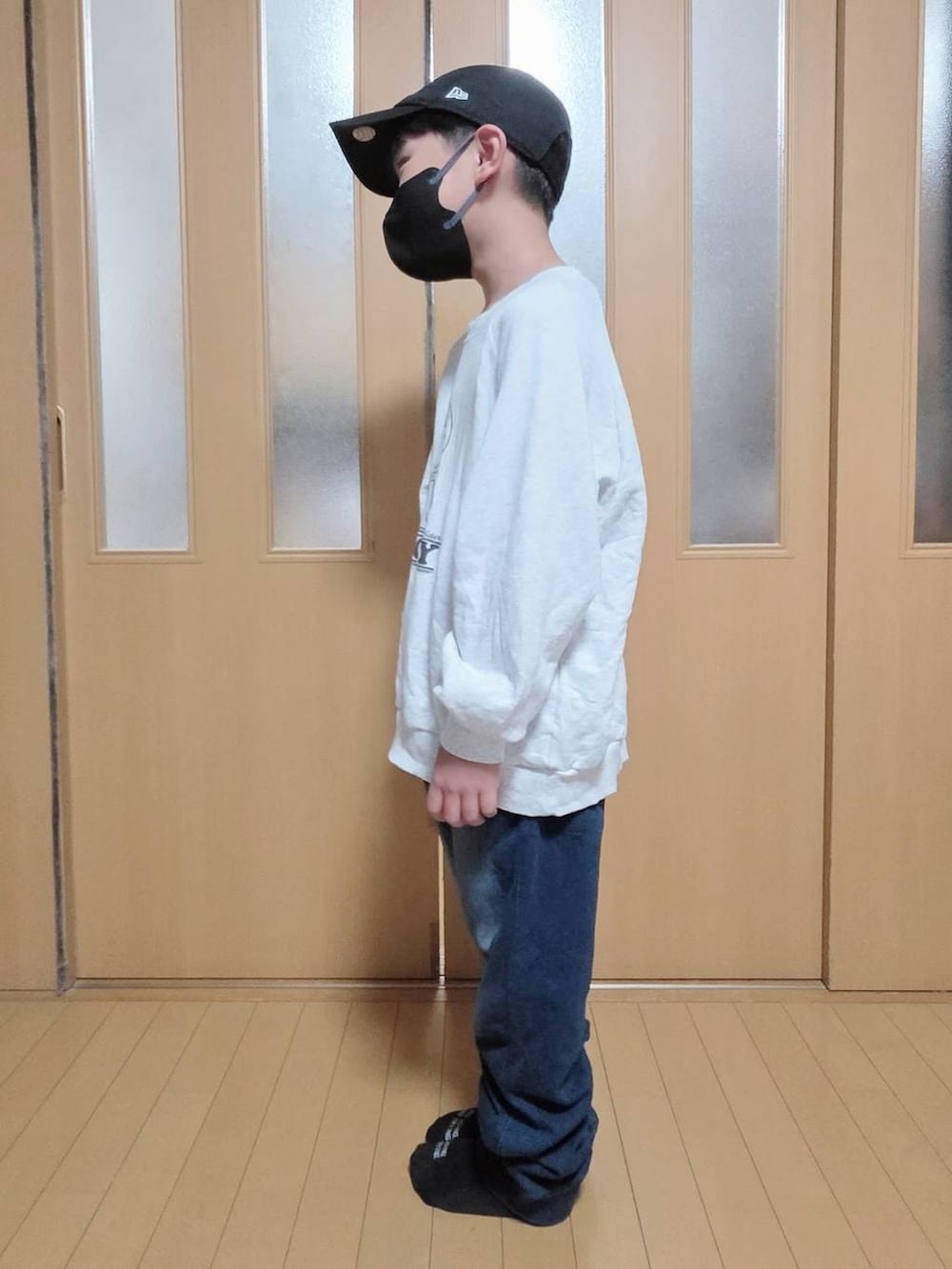 ベージュ系のブルゾン、ブルー系のデニムパンツ、グレー系のスウェットを着用したキッズの秋コーディネートの5枚目の写真