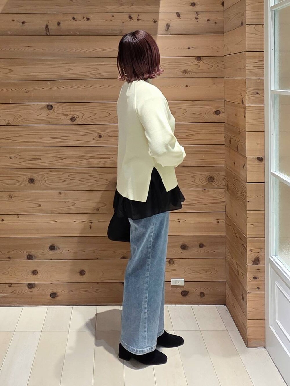 ブラック系のショルダーバッグ、ブルー系のダウンジャケット/コート、ブラック系のTシャツ/カットソーを着用したレディースの冬コーディネートの2枚目の写真