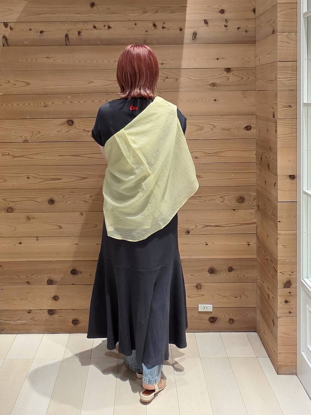 ブルー系のデニムパンツ、イエロー系のシャツ/ブラウス、シルバー系のショルダーバッグを着用したレディースの夏コーディネートの3枚目の写真