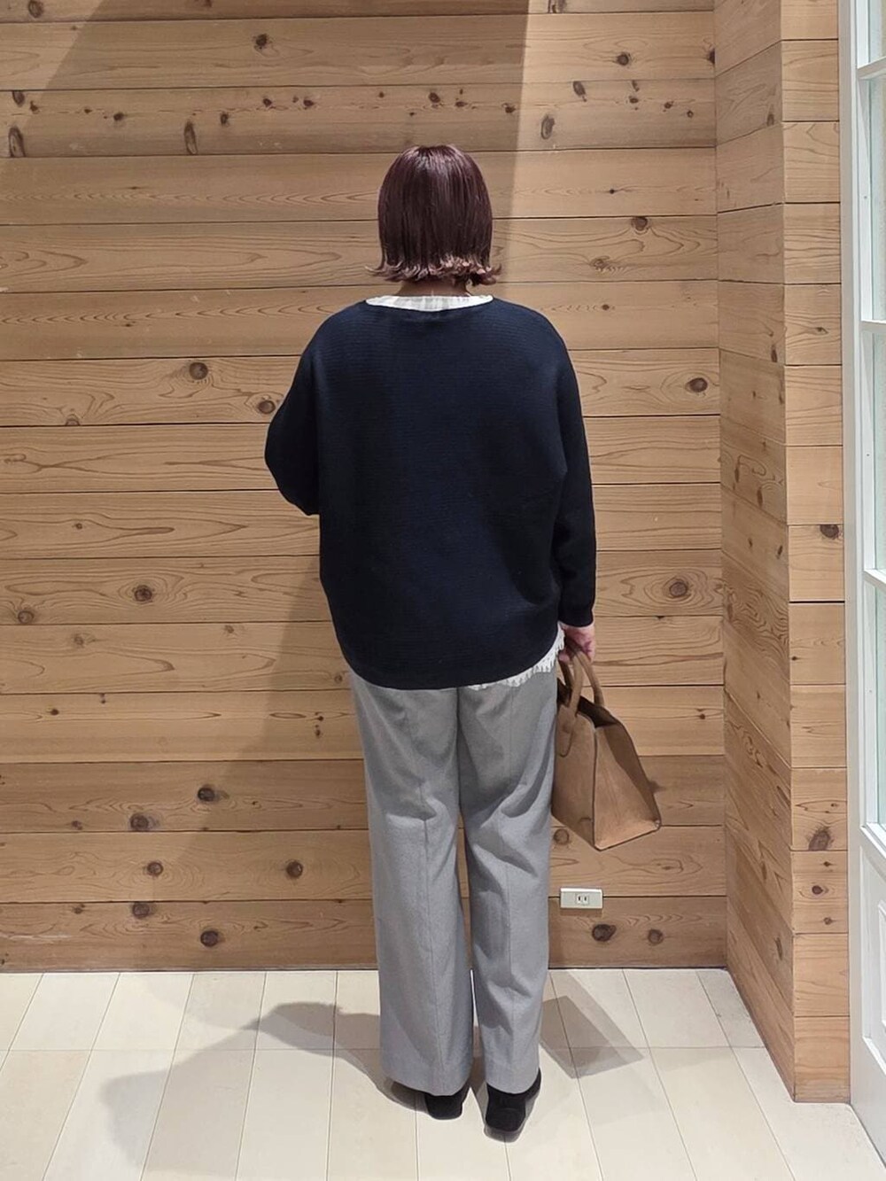 ブラウン系のチェスターコート、グレー系のその他パンツ、ベージュ系のショルダーバッグを着用したレディースの冬コーディネートの3枚目の写真