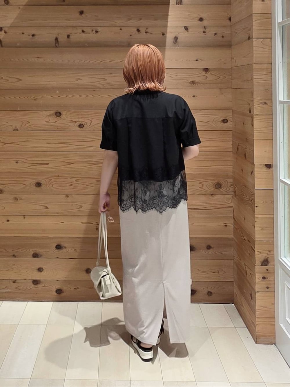 ホワイト系のスカート、ベージュ系のショルダーバッグ、ブラック系のサンダルを着用したレディースの夏コーディネートの3枚目の写真