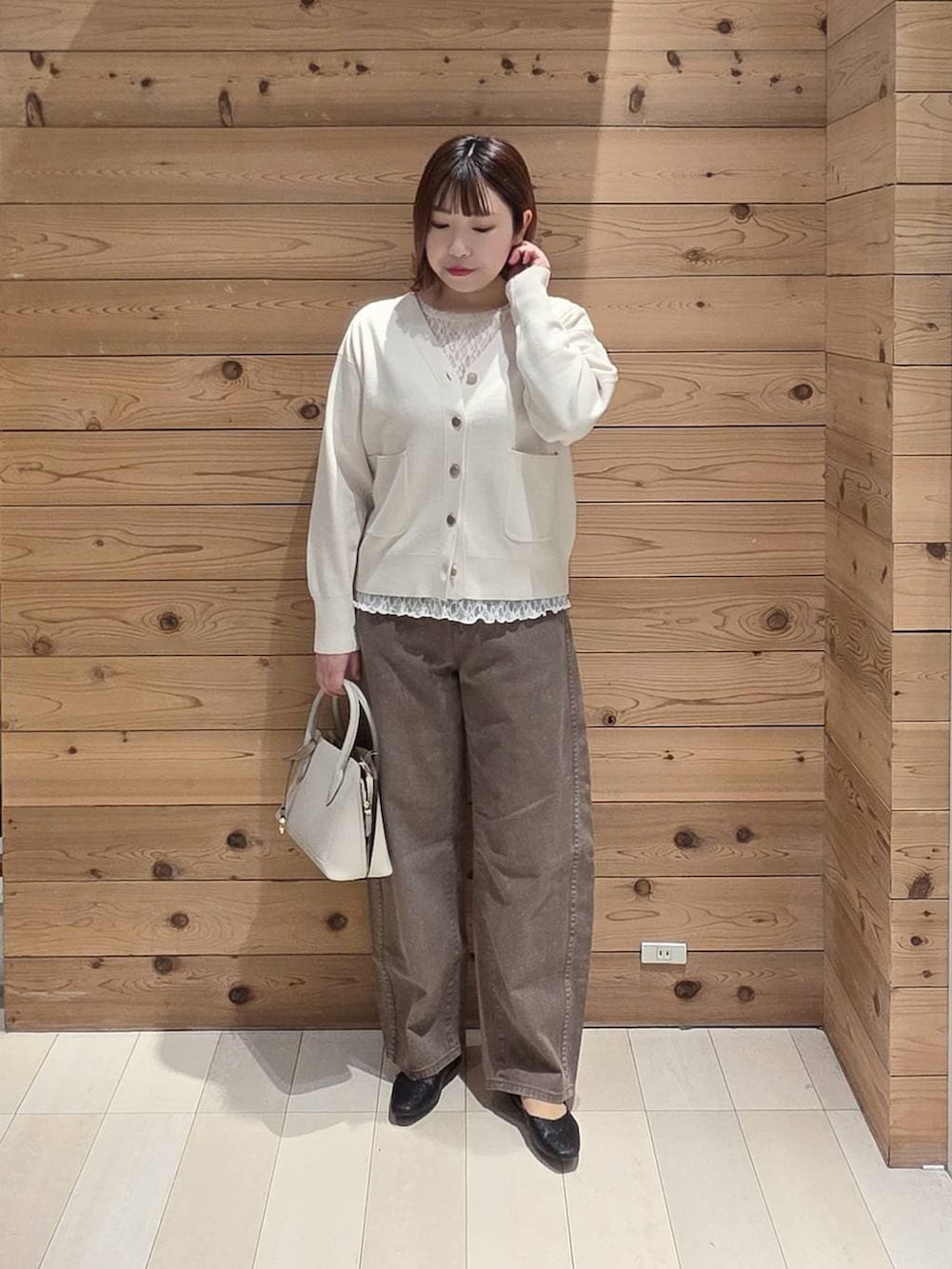 ブラック系のパンプス、ホワイト系のショルダーバッグ、ブラック系のマウンテンパーカーを着用したレディースの春コーディネートの4枚目の写真