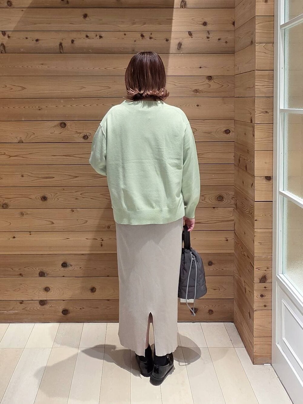 ブラック系のローファー、グレー系のハンドバッグ、ホワイト系のスカートを着用したレディースの春コーディネートの3枚目の写真