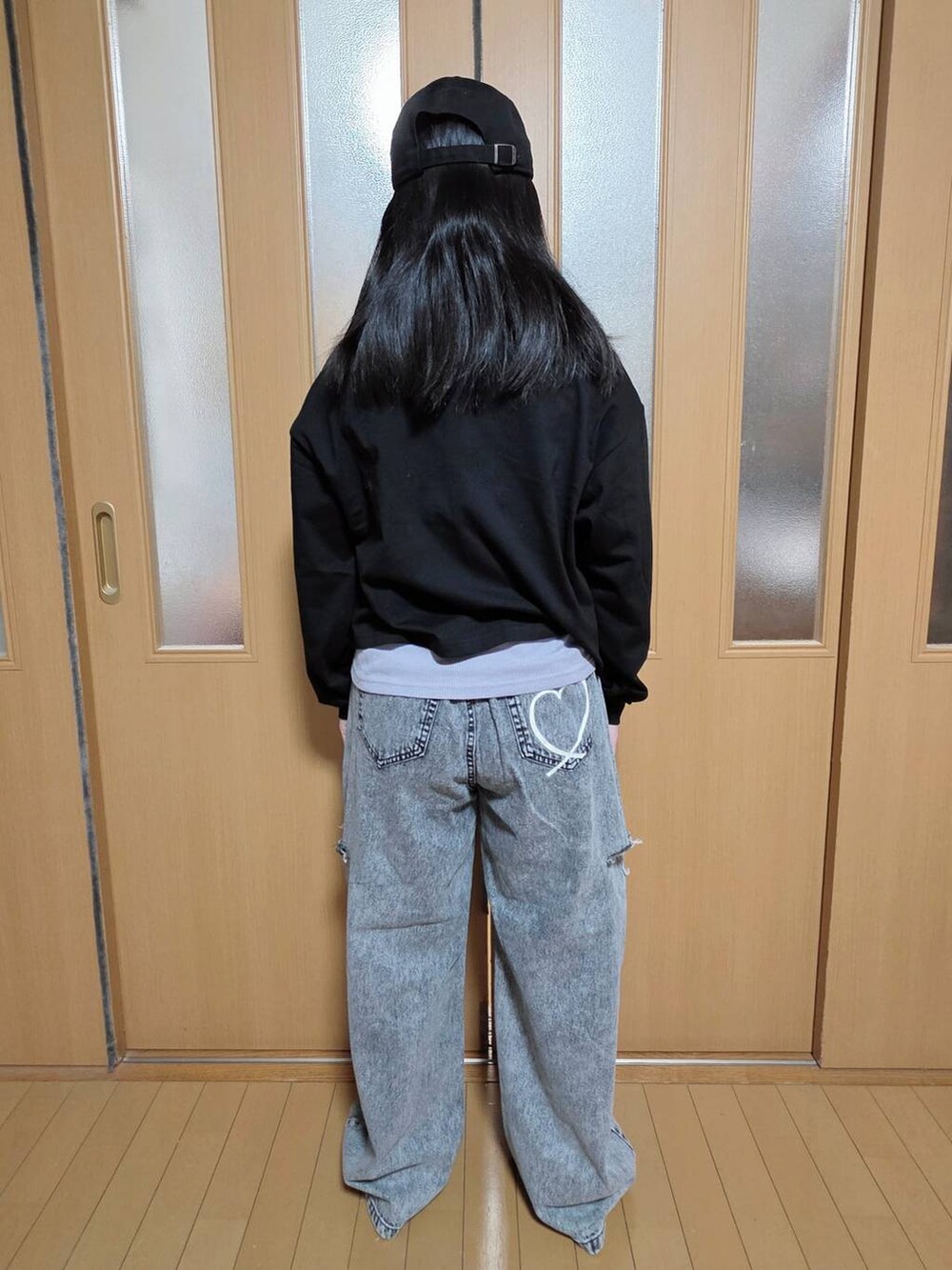 ブラック系のデニムパンツ、ホワイト系のマウンテンパーカー、ブラック系のTシャツ/カットソーを着用したキッズの秋コーディネートの3枚目の写真