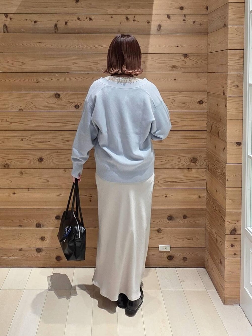 ブラック系のローファー、ブラック系のボストンバッグ、ブラック系のマウンテンパーカーを着用したレディースの春コーディネートの3枚目の写真