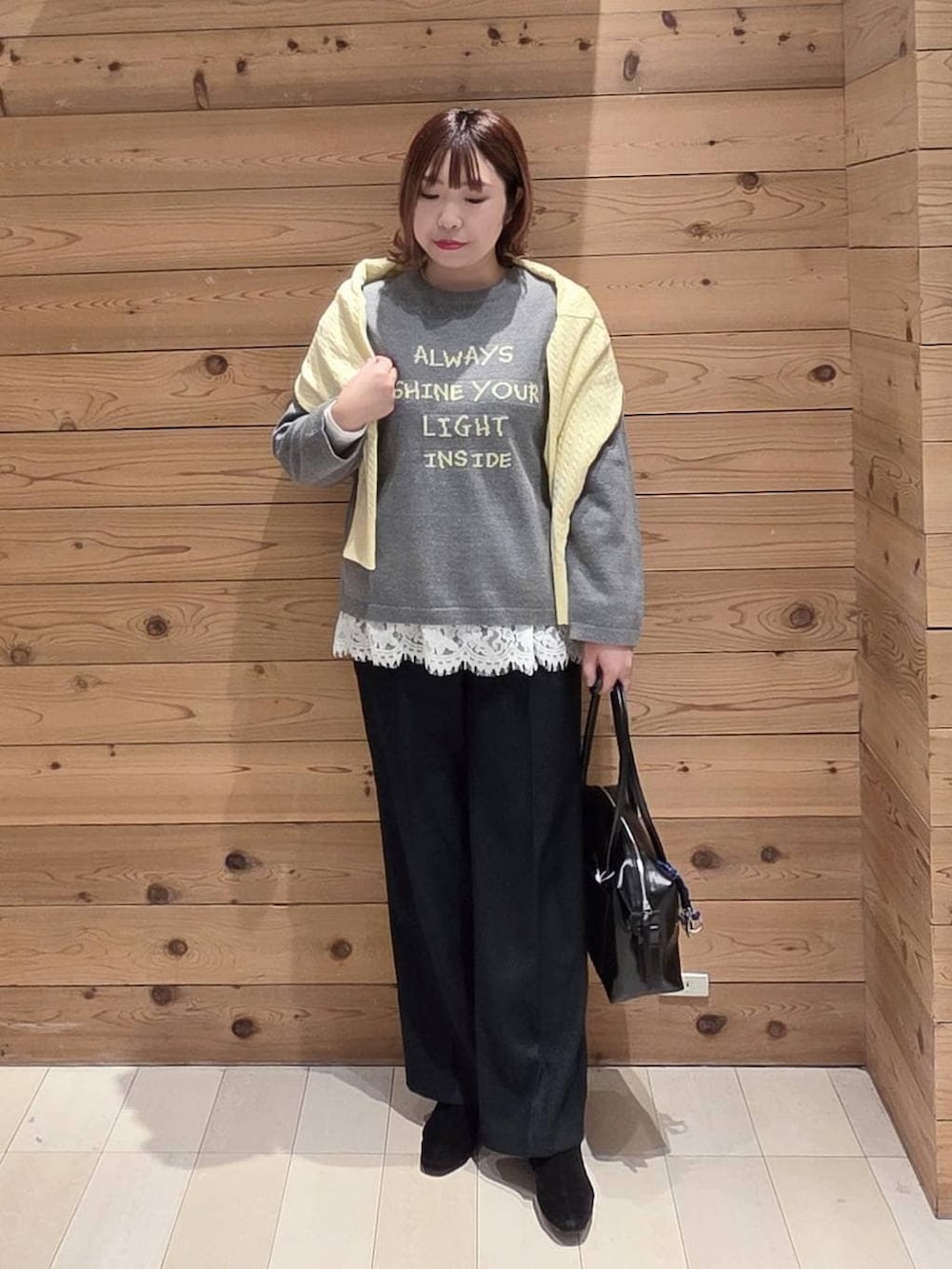 ブラック系のボストンバッグ、グレー系のチェスターコート、ブラック系のその他パンツを着用したレディースの冬コーディネートの4枚目の写真