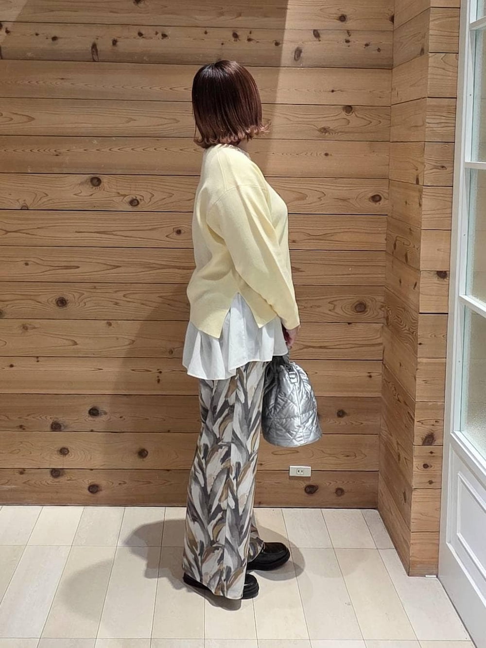 ブラック系のローファー、シルバー系のハンドバッグ、ホワイト系のTシャツ/カットソーを着用したレディースの冬コーディネートの2枚目の写真