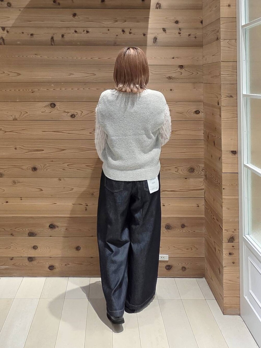ホワイト系のカーディガン/ボレロ、ベージュ系のベスト、ブラック系のローファーを着用したレディースの秋コーディネートの3枚目の写真