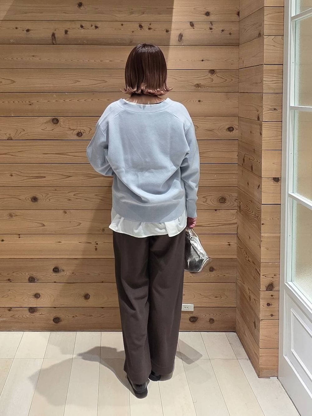 シルバー系のショルダーバッグ、ブラック系のローファー、ブラック系のマウンテンパーカーを着用したレディースの春コーディネートの3枚目の写真