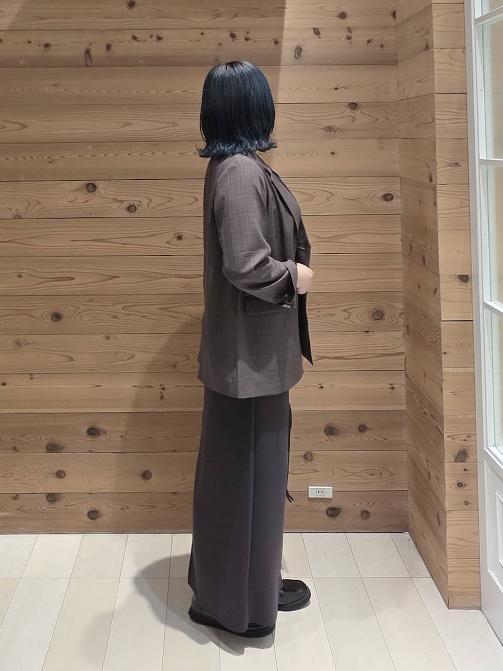 ブラック系のローファー、ブラック系のハンドバッグ、ブルー系のTシャツ/カットソーを着用したレディースの秋コーディネートの2枚目の写真