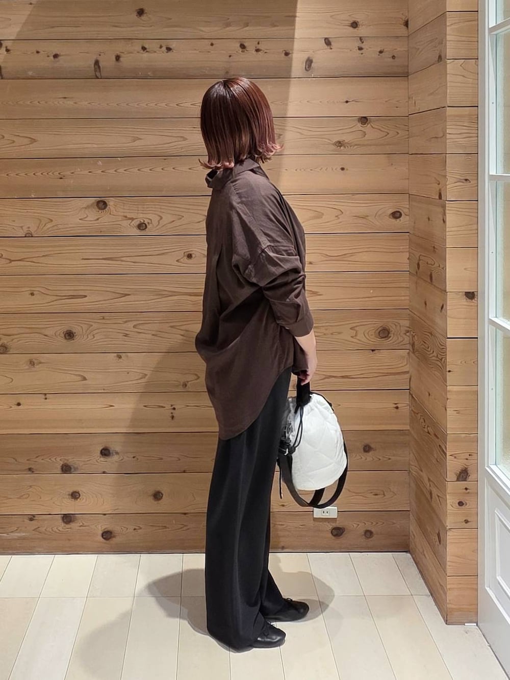 ブラック系のバレエシューズ、ホワイト系のハンドバッグ、ブラウン系のシャツ/ブラウスを着用したレディースの春コーディネートの2枚目の写真